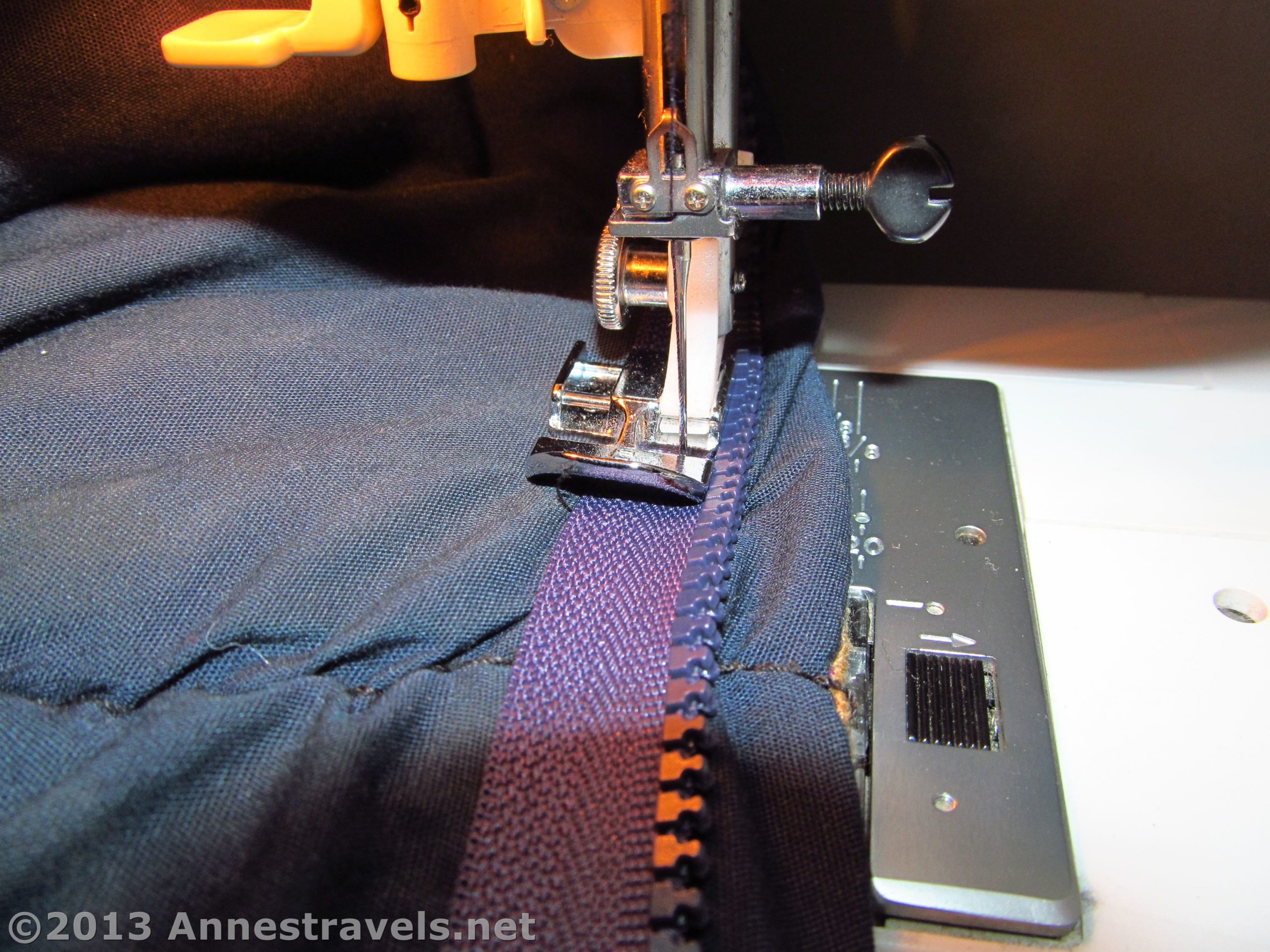 Using a sewing machine to sew a new zipper to a sleeping bag