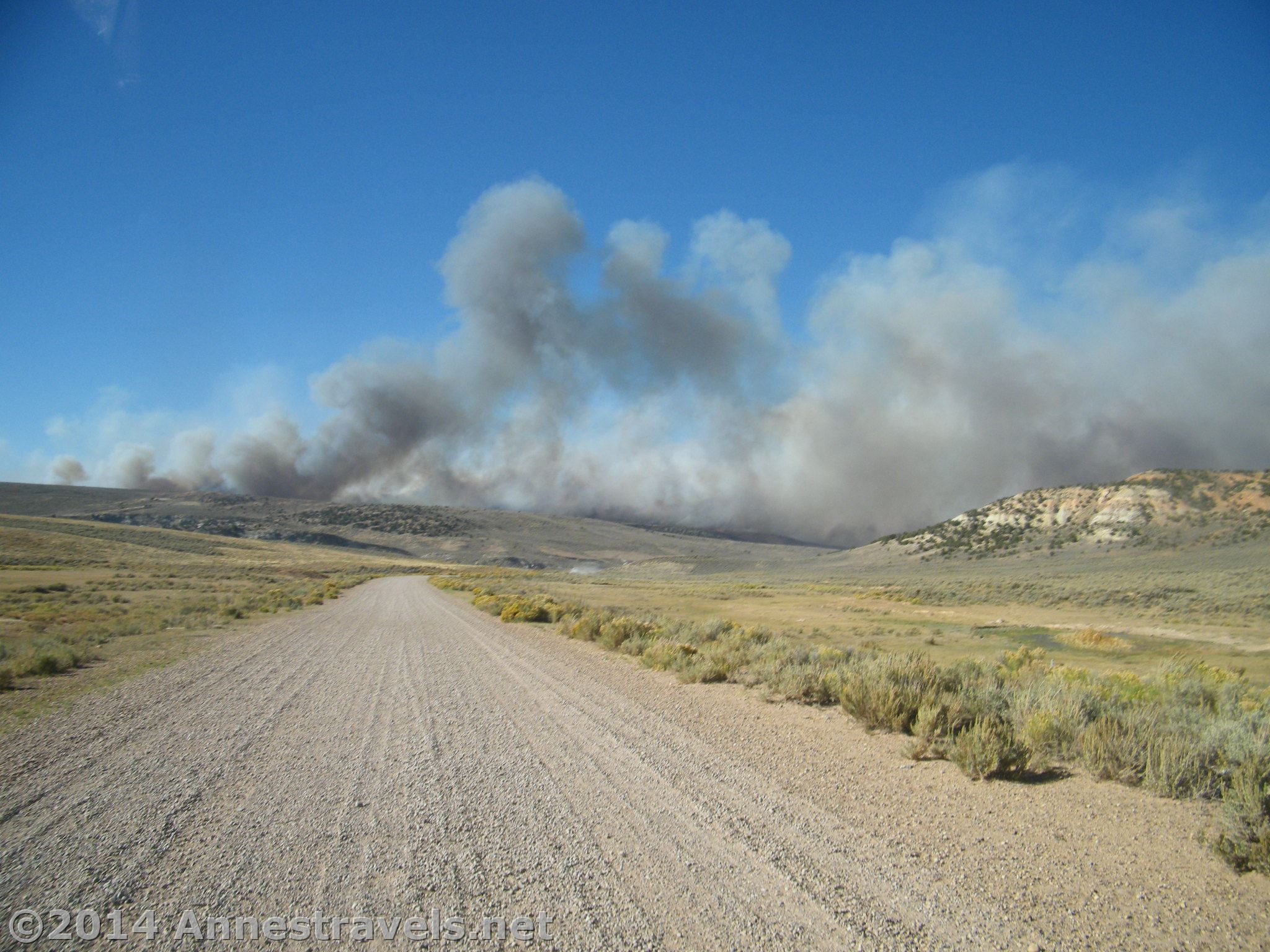 Smoke pours up from a wildfire next to I-80 in Wyoming. We're on a dirt road to the the south of the highway.
