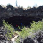 Walking into the entrance of Indian Well Cave in Lava Beds National Monument, California