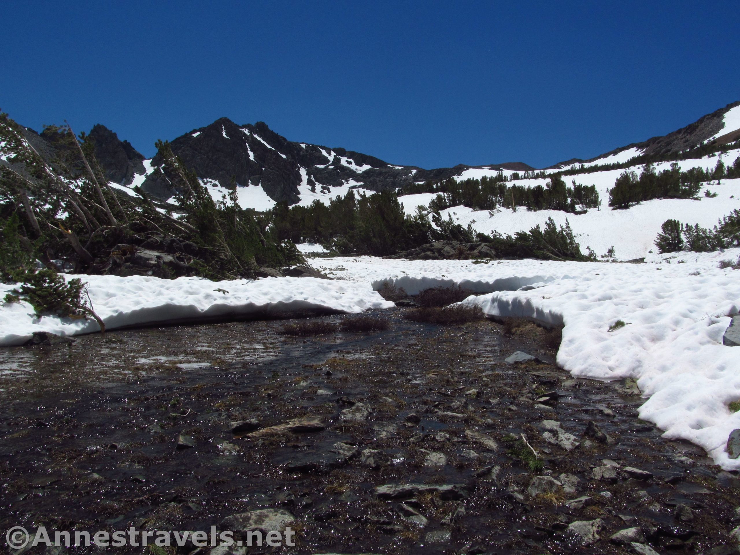 A stream frees itself of the snow in the cirque below Burro Pass above the Virginia Lakes in Humboldt-Toiyabe National Forest, California