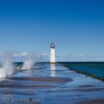 Waves on the pier and lighthouse at Sodus Point Beach Park, Sodus, New York