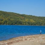 A child on the beach near the Hemlock Lake Trail North Trailhead, Finger Lakes, New York