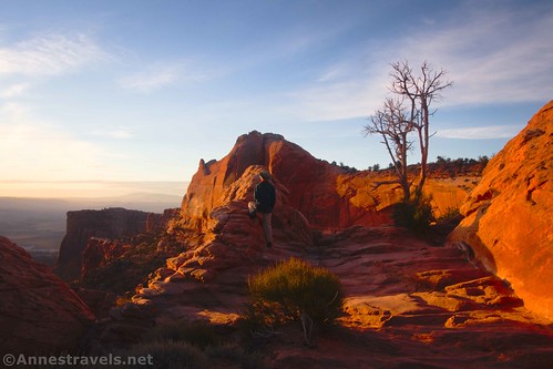 A hiker to the right of Mesa Arch, enjoying the views.  Island in the Sky District, Canyonlands National Park, Utah