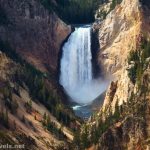 A huge waterfall between yellow cliffs of a canyon