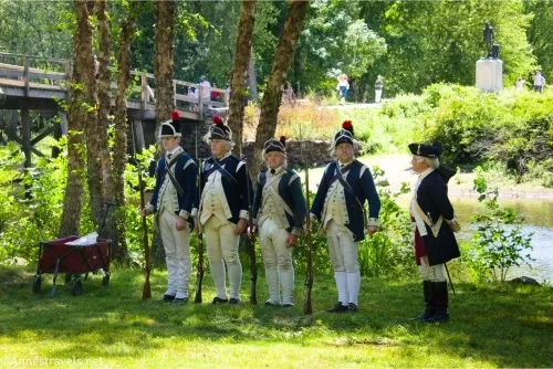 Soldiers stand with their muskets along the river waiting for the Declaration of Independence to be read at North Bridge, Minute Man National Historical Park, Massachusetts