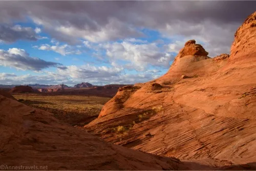 Majestic clouds over red rocks and distant views with a trail marked on the rock with stones