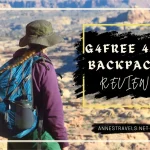 A woman with a dark green hat, a blue backpack, and a purple jacket stands on the edge of a rugged desert landscape. Text reads, G4Free 45L Backpack Review.