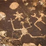 Wild figures inscribed in a dark rock