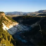 Morning sun on the cliffs of a river gorge with distant tall hills