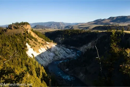 Morning sun on the cliffs of a river gorge with distant tall hills