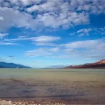 Clouds over a lake in a desert valley with mountains on either side