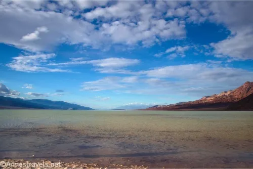 Clouds over a lake in a desert valley with mountains on either side