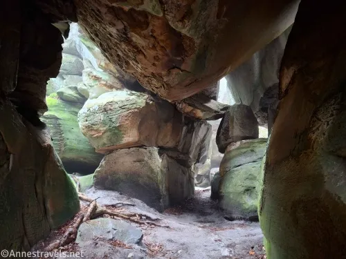 Rocks with moss above and around a sandy dirt floor