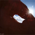 Silhouette of a hole in a rock and a sunstar