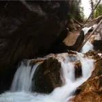 A waterfall tumbles in a gorge over rocks